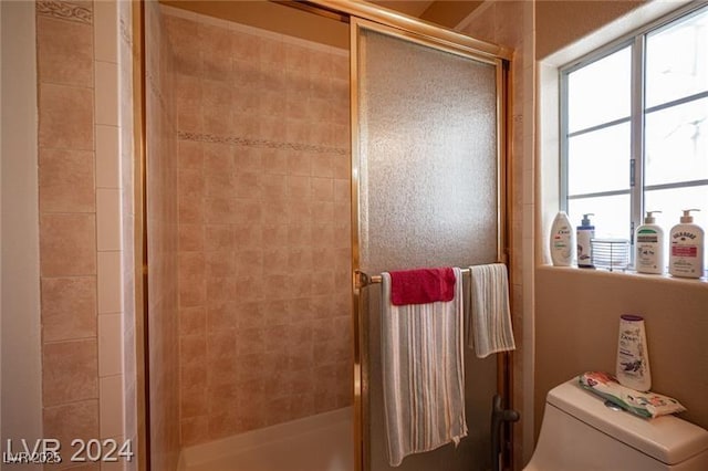 bathroom with toilet and a shower stall