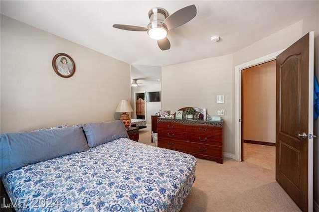 bedroom with light carpet, ceiling fan, and baseboards