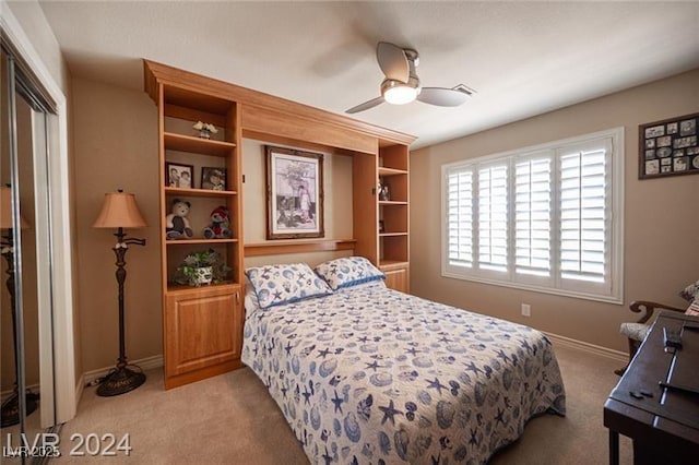 bedroom featuring baseboards, ceiling fan, a closet, and light colored carpet