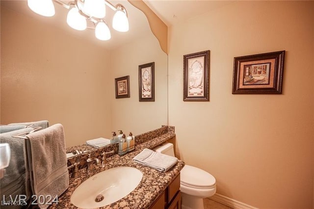 bathroom with baseboards, vanity, and toilet