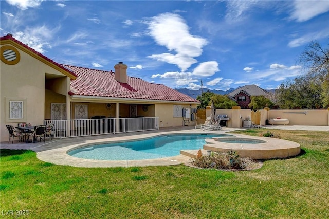 view of pool with an in ground hot tub, a yard, a patio area, and fence