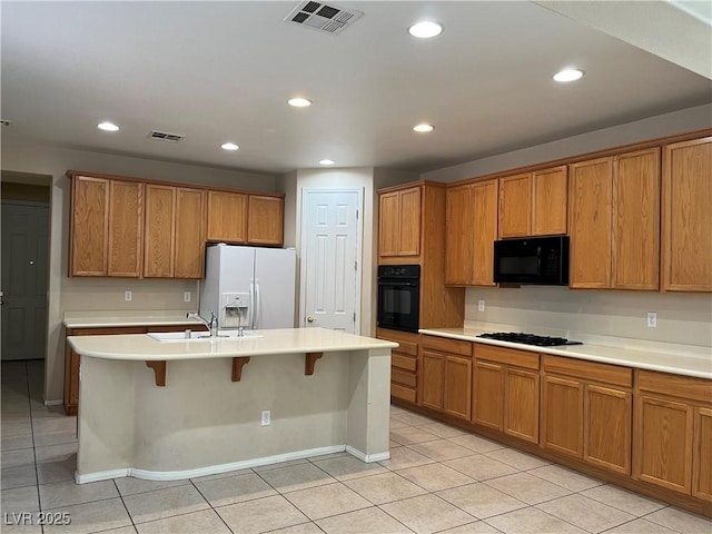2461 Brooklyn Bridge St, Las Vegas, NV 89135 - kitchen with brown cabinetry, visible vents, black appliances, and a sink