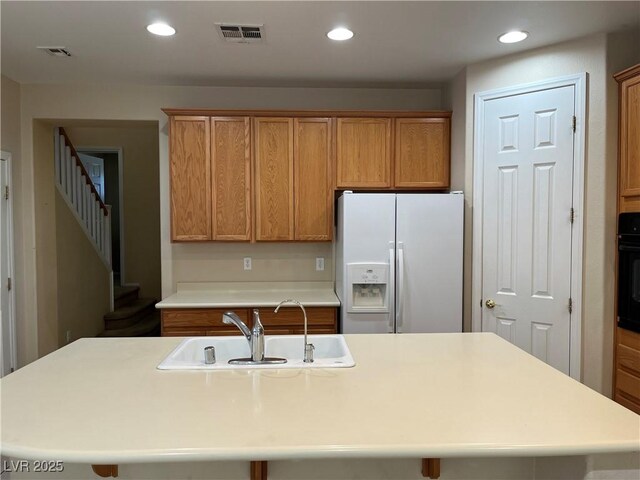 2461 Brooklyn Bridge St, Las Vegas, NV 89135 - kitchen featuring visible vents, black oven, recessed lighting, white refrigerator with ice dispenser, and a sink