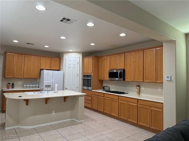 2461 Brooklyn Bridge St, Las Vegas, NV 89135 - kitchen featuring appliances with stainless steel finishes, light tile patterned floors, light countertops, a breakfast bar, and recessed lighting