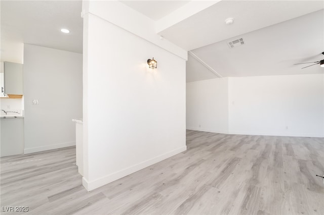 additional living space featuring baseboards, light wood-style flooring, visible vents, and a ceiling fan