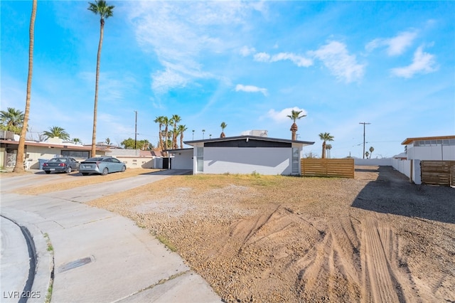 view of front of property featuring driveway and fence