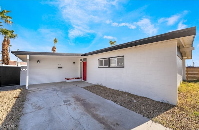 ranch-style house with fence and concrete block siding