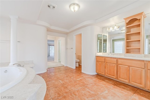 bathroom with a garden tub, decorative columns, visible vents, toilet, and vanity