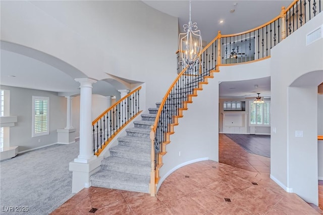 stairs featuring arched walkways, visible vents, plenty of natural light, and ornate columns