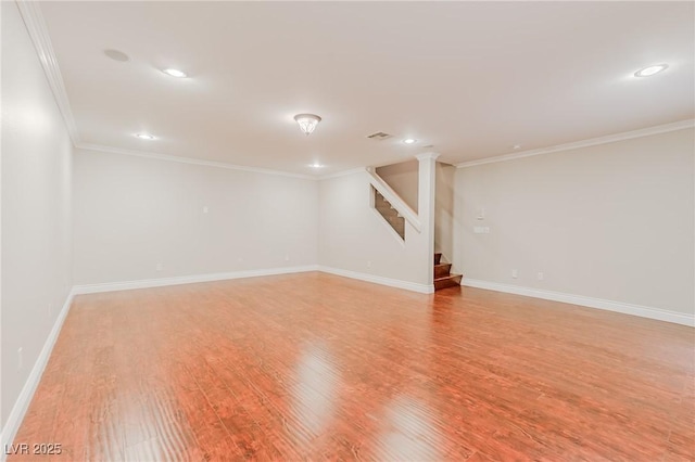 finished below grade area featuring light wood-type flooring, stairs, baseboards, and ornamental molding