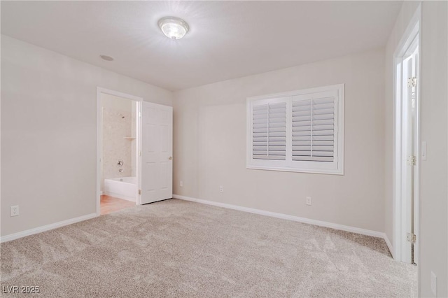 unfurnished bedroom featuring carpet floors, baseboards, and ensuite bathroom