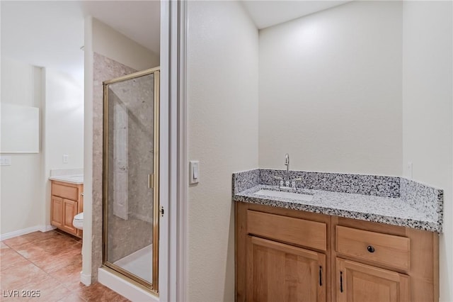 bathroom with baseboards, toilet, tile patterned floors, vanity, and a shower stall