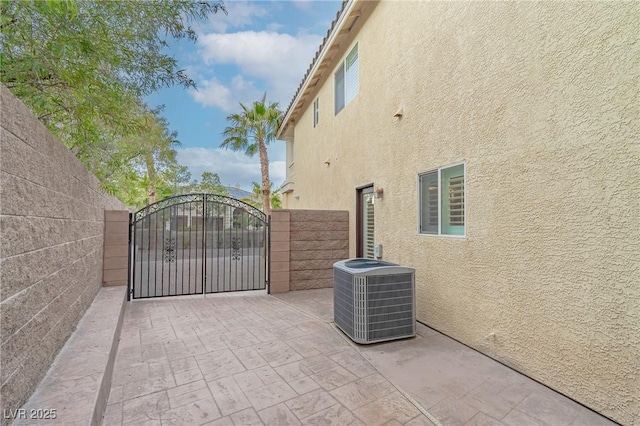 view of gate featuring central AC and fence