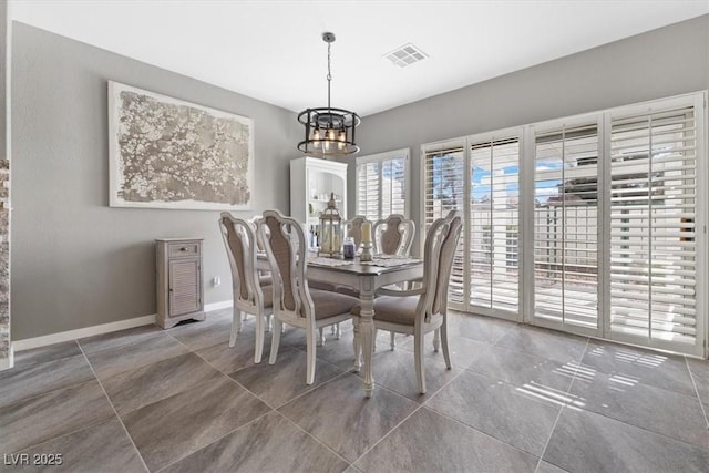 dining space with an inviting chandelier, visible vents, and baseboards