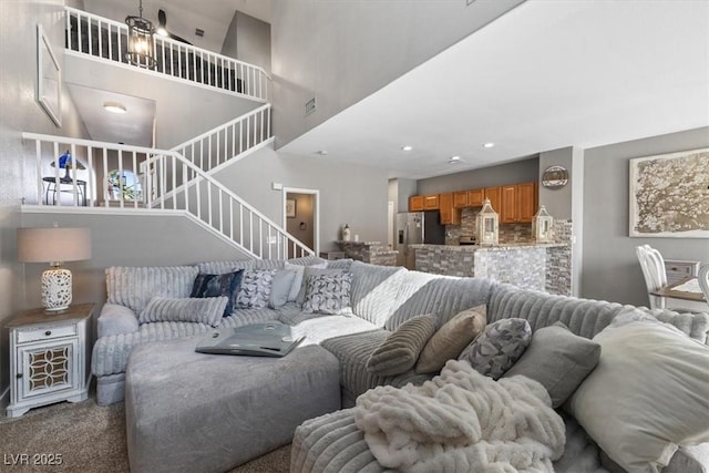 carpeted living area featuring stairs, visible vents, and recessed lighting