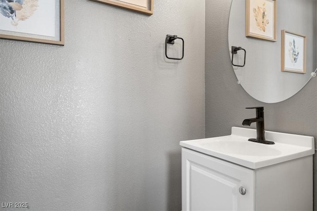 bathroom with a textured wall and vanity