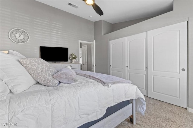 bedroom featuring a closet, visible vents, ceiling fan, and light carpet