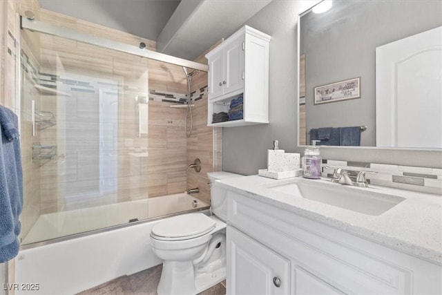 full bathroom with bath / shower combo with glass door, vanity, and toilet