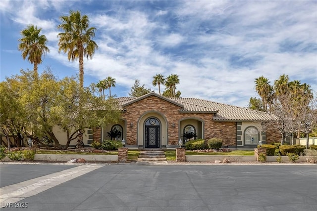 mediterranean / spanish-style home with a tiled roof and stucco siding