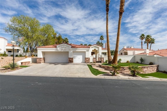 mediterranean / spanish home featuring concrete driveway, a tiled roof, an attached garage, fence, and stucco siding