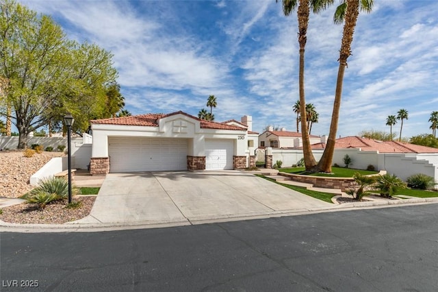 mediterranean / spanish-style house with concrete driveway, a tile roof, an attached garage, fence, and stucco siding