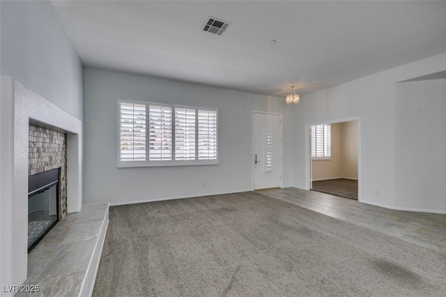 unfurnished living room featuring carpet, a fireplace, and visible vents