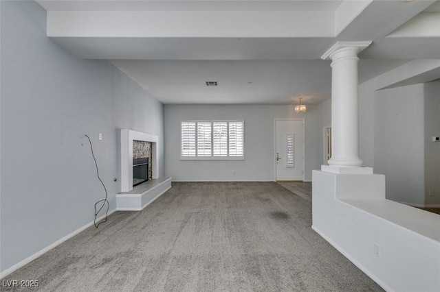 unfurnished living room with carpet, decorative columns, visible vents, and a glass covered fireplace