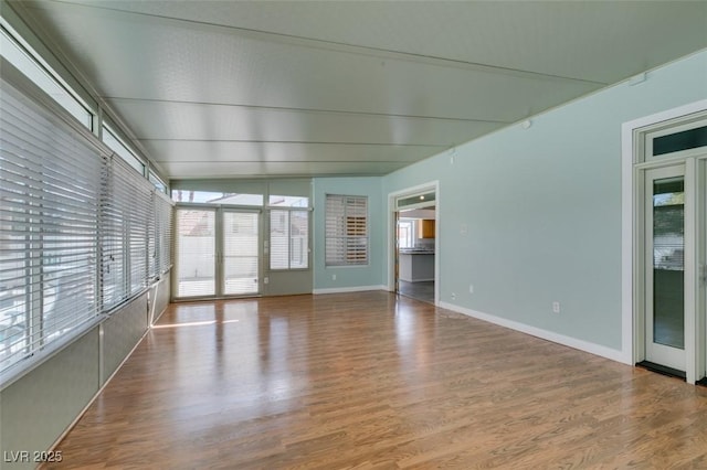 interior space with plenty of natural light, baseboards, and wood finished floors