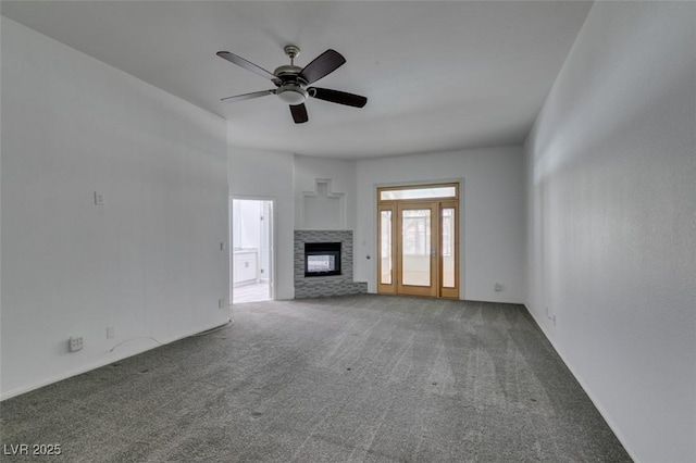 unfurnished living room with carpet floors, a glass covered fireplace, and ceiling fan