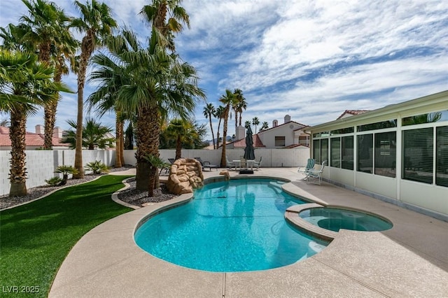 view of swimming pool with a sunroom, a patio, a fenced backyard, and a pool with connected hot tub