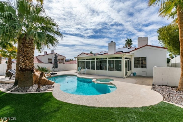 view of pool with a lawn, a patio, a sunroom, a fenced backyard, and a pool with connected hot tub