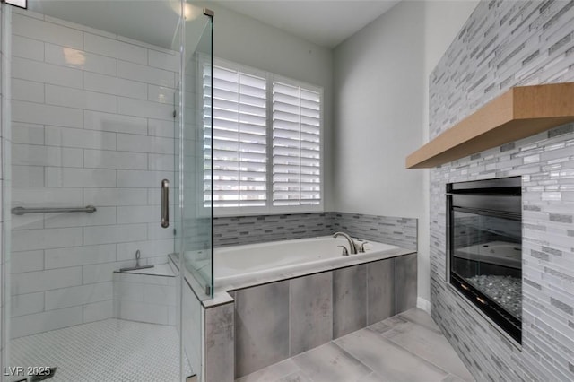 bathroom featuring a garden tub and a shower stall