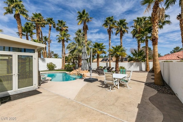 view of swimming pool with a fenced in pool, french doors, a patio area, and a fenced backyard