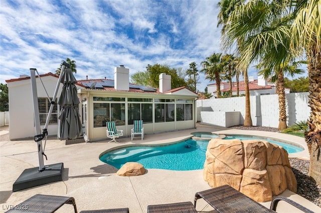 view of pool featuring a patio area, a fenced backyard, a pool with connected hot tub, and a sunroom