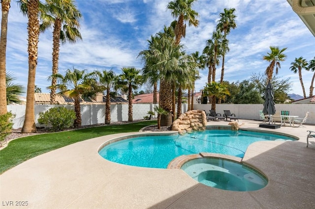 view of pool featuring a pool with connected hot tub, a patio area, and a fenced backyard