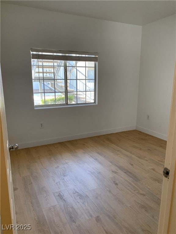 unfurnished room featuring baseboards and wood finished floors