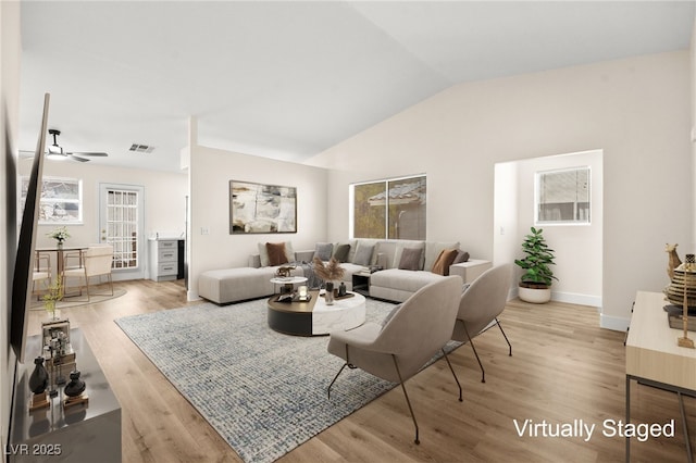 living room with ceiling fan, visible vents, vaulted ceiling, and wood finished floors