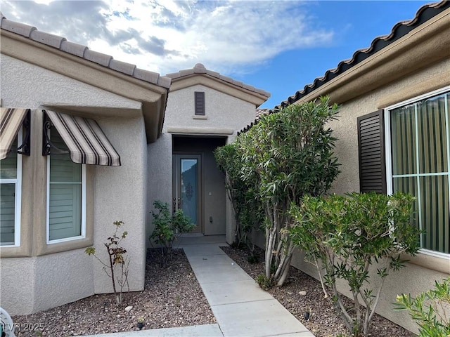 entrance to property featuring stucco siding