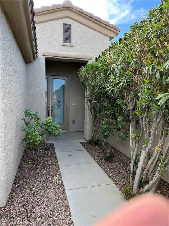 view of exterior entry featuring stucco siding