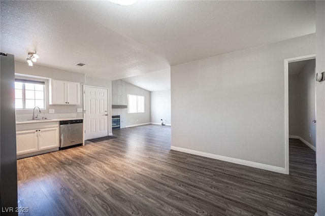 kitchen featuring lofted ceiling, stainless steel appliances, visible vents, a wealth of natural light, and dark wood-style floors