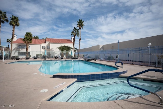 pool featuring a patio, a community hot tub, and fence