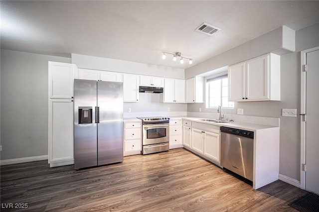 kitchen featuring light countertops, visible vents, appliances with stainless steel finishes, white cabinetry, and a sink