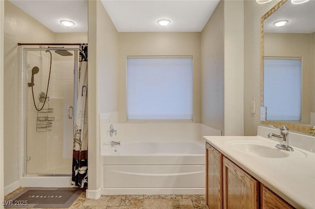 full bathroom with vanity, a bath, and a shower stall