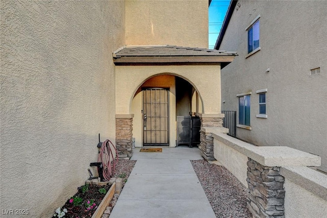 property entrance with stucco siding and stone siding