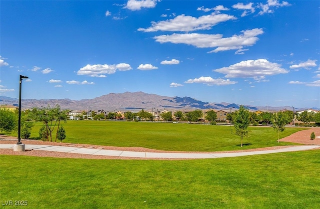 view of property's community featuring a lawn and a mountain view