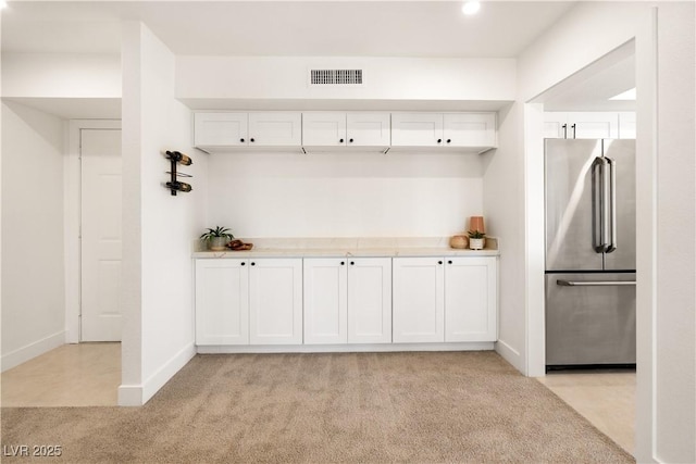 mudroom featuring light colored carpet, visible vents, and baseboards