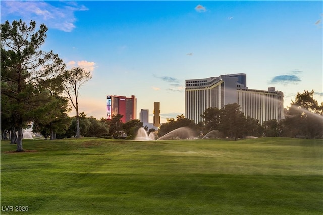 view of home's community featuring a lawn and a city view