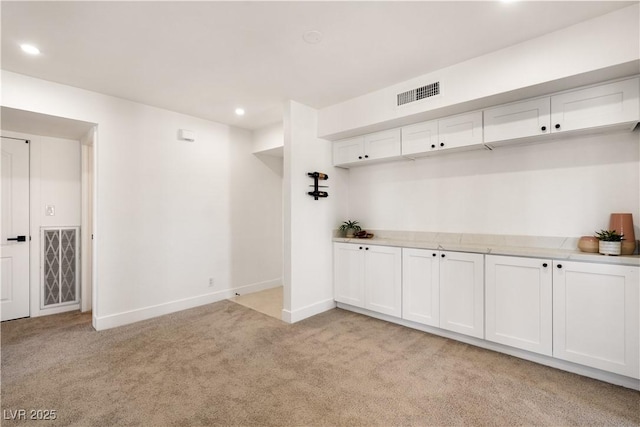 mudroom featuring light carpet, recessed lighting, visible vents, and baseboards