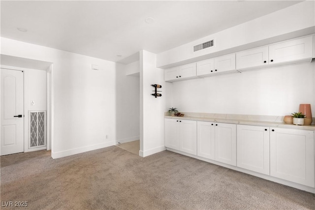 mudroom featuring baseboards, visible vents, and light colored carpet