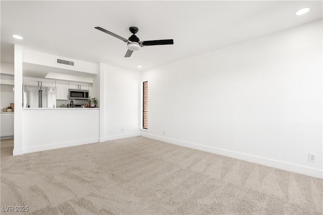 unfurnished living room with recessed lighting, visible vents, a ceiling fan, light carpet, and baseboards